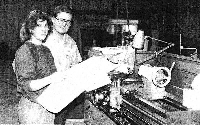Old black & white newspaper clip with man & woman by MTE machines